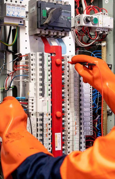 Licensed electrician performing panel maintenance.